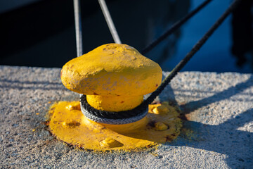 Wall Mural - Mooring bollard concept. Ropes twisted with knobs on yellow metal bollard.