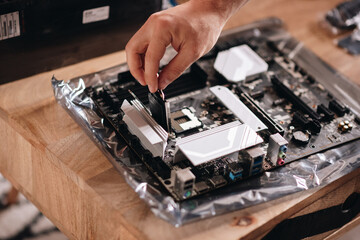 Wall Mural - Closeup shot of a hand of the technician repairing the pc motherboard