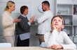 © JackF - Portrait of unhappy boy sitting at home while parents and grandma quarreling