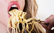 Close up sexy lips with noodles pasta. Female mouth eat spaghetti.