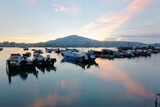 Fototapeta Boho - Morning scenery of Tamsui River at sunrise in Bali District, Taipei, Taiwan, with a peaceful view of ferry boats parking on the smooth water & Datun Mountain under beautiful dawning sky in background