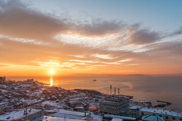 Wall Mural - Sunset over a city covered in snow