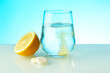 effervescent vitamin C tablet dissolves in water. a glass of water, effervescent tablet and citrus fruit on blue background. vitamin C concept