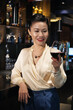 © DragonImages - Beautiful smiling woman looking at glass of tasty red wine in her hand
