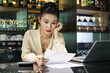© DragonImages - Pensive tired bar and restaurant owner reading sales report and analyzing income