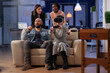 © DC Studio - Cheerful multi ethnic friends enjoy vr glasses experience after work at office party. Diverse people play with controller joystick on tv console having fun together bonding at celebration