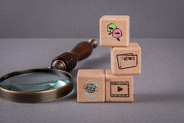 Sticker - social media and content concept. magnifying glass and wooden blocks on a gray background