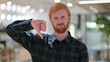 © stockbakers - Portrait of Redhead Man with Thumbs Down Gesture