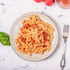 Vegetarian girandole pasta with red tomato sauce - portion in a plate on the table, top view