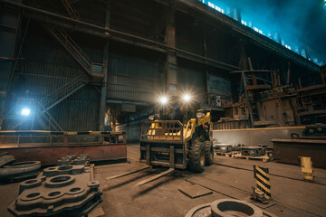 Wall Mural - Small loading tractor or mower at work in metallurgical factory workshop.