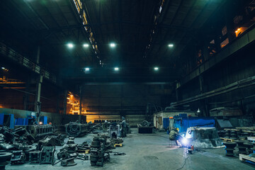 Wall Mural - Metallurgical factory workshop interior with working welder and metal products ready for processing, heavy industry.