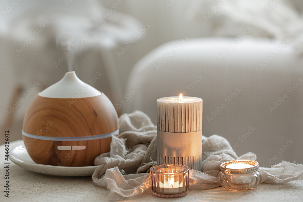 Cozy home composition with air humidifier and candles on blurred background. - obrazy, fototapety, plakaty 