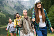 © NDABCREATIVITY - Adventure, travel, tourism, hike and people concept. Group of happy friends with backpack outdoors