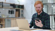 © stockbakers - Redhead Man working on Smartphone and Laptop