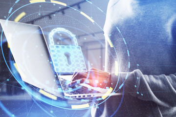 Poster - Close up of hacker hands using laptop with glowing padlock hologram on blurry office background. Online safety and attack concept. Double exposure.