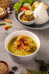 Wall Mural - Nasi Soto Ayam or Soto Medan with prawn is  Traditional chicken soup with rice from North Sumatra. 

Soto is a traditional Indonesian soup mainly composed of broth, meat, fried patties and vegetables.