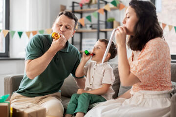 Wall Mural - family, holidays and people concept - happy mother, father and little son with gifts and party blowers having fun and celebrating birthday at home