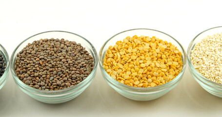 Wall Mural - Closeup shot of various lentils in plates isolated on a white background