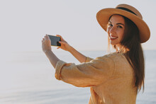 Side View Happy Young Woman In Straw Hat Shirt Summer Casual Clothes Take Photo Of Landscape By Mobile Cell Phone Outdoors At Sunrise Sun Dawn Over Sea Beach People Vacation Lifestyle Journey Concept