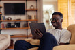 © bnenin - African man, enjoying his hobbies, at home.