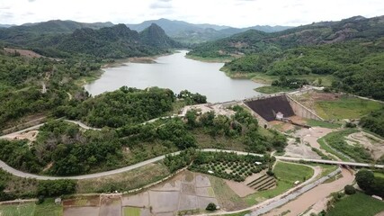 Wall Mural - Aerial view of Mae Suai reservoir (or Dammed valleys) located at a narrow part of a valley downstream of a natural basin in Mae Suai district of Chiang Rai province of Thailand.