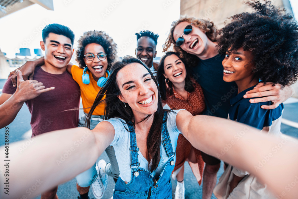 Multicultural happy friends having fun taking group selfie portrait on city street - Multiracial young people celebrating laughing together outdoors - Happy lifestyle concept - obrazy, fototapety, plakaty 