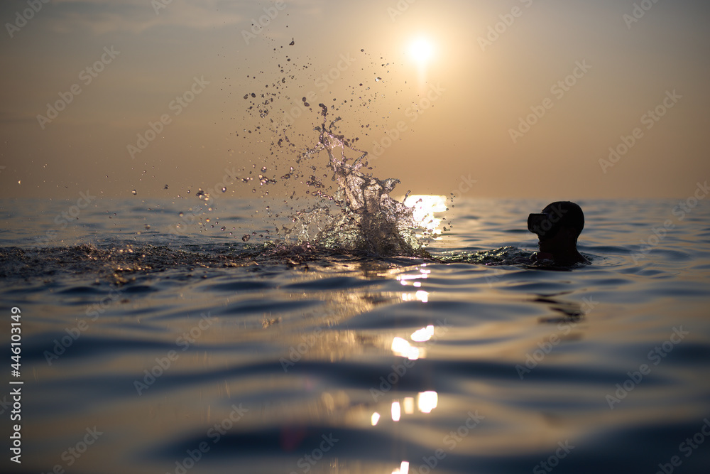 Młodzi przyjaciele kąpią się w morzu o zachodzie słońca. Sepia, backlight, silhouette. - obrazy, fototapety, plakaty 