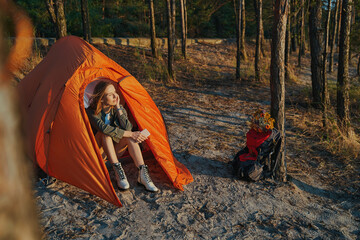 Calm woman inside tent is admiring sunset