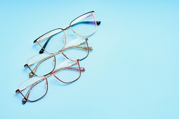 Wall Mural - pair of red plastic-rimmed eyeglasses on a blue background