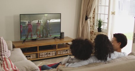 Canvas Print - Composite of happy family sitting at home together watching hockey match on tv