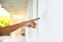 Student Is Using His Hand To Turn Off The Light Switch Panel On The Wall In Front Of His Class Before Going Back Home, Soft And Selective Focus, Sunlight Edited Background.