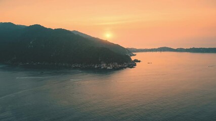 Canvas Print - Aerial view orange sunset over sea and mountains. Pink sky and bright sun over green island and blue ocean water. Summer sunset seascape. Holidays in Mallorca on Mediterranean sea.