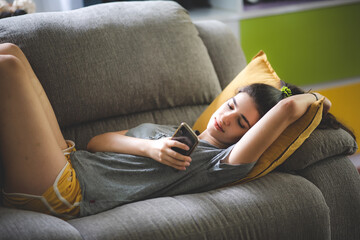 young woman pretty girl living and resting peace on cozy sofa, couch enjoying, lying relax at indoor