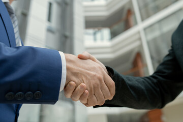 Poster - Close-up of two architects shaking hands against the office building