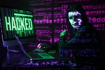 Hacker using computer in dark room