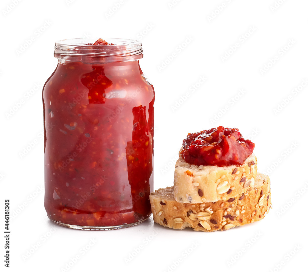 Jar of tasty salsa sauce and bread on white background