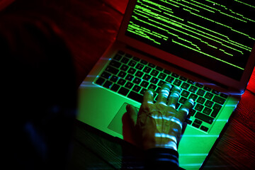 Hacker using computer in dark room