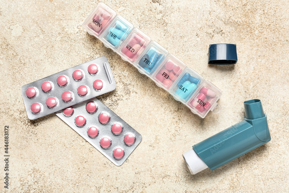 Modern inhaler and pills on grunge background