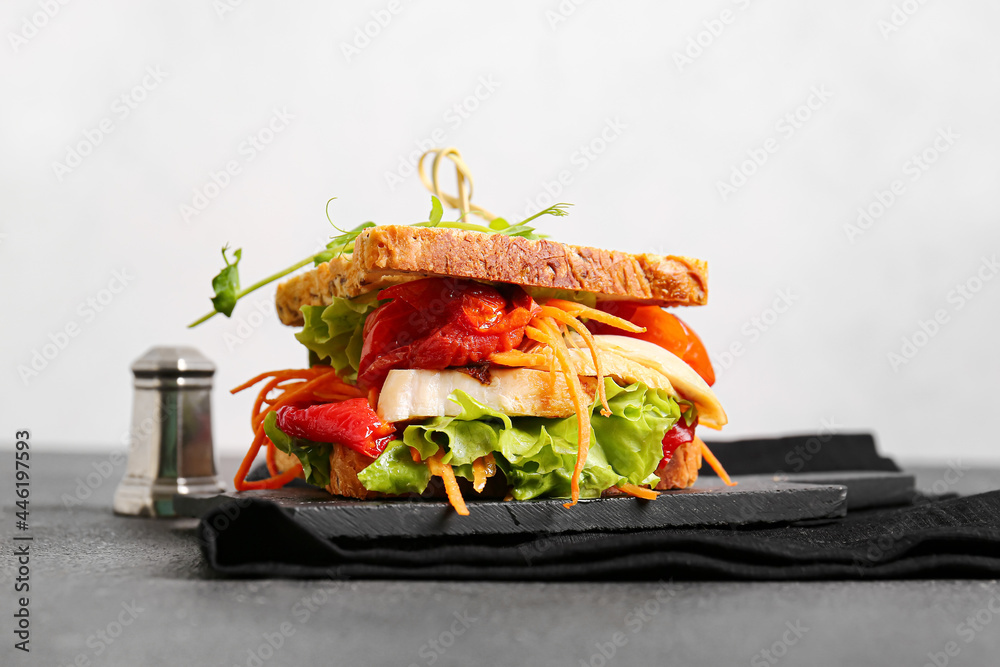 Board with tasty sandwich on dark table, closeup