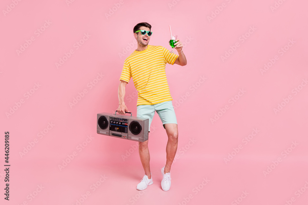 Full body photo of cheerful young happy man hold hand boombox cocktail look empty space isolated on pink color background - obrazy, fototapety, plakaty 