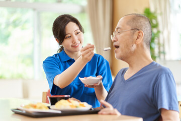 Wall Mural - 高齢者に食事の介助をする介護士