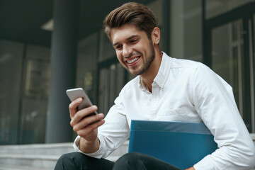 Business man sit on stairs and using mobile phone