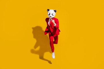 Poster - Photo of incognito panda guy jump run fast wear mask red tuxedo footwear isolated on yellow color background