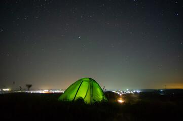 Wall Mural - night landscape tent against the background of the starry sky and city lights
