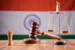 Concept of Indian justice system showing by using Judge Gavel, Balance scale on Indian flag as background
