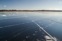 Frozen Lake Usma With Cracked Ice. Sunny Winter Day Without Snow. 