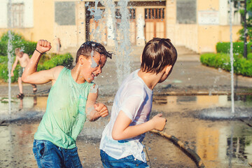 Happy friends having fun in fountain. Summer weather. Friendship, lifestyle and vacation.