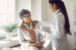 © Studio Romantic - Female doctor with happy elderly woman patient talking in hospital office. Young female physician telling good news to aged lady holding test or treatment result clipboard in hand. Medical support