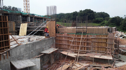 Sticker - PENANG, MALAYSIA -MAY 3, 2020: Structural work is underway at the construction site. Work is carried out in stages according to the sequence of work. The workers practice standard safety methods.
