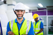 © winnievinzence - Portrait of confident male engineer foreman in safety helmet smile in arms crossed stand in front of factory production. man operating machine at industrial plant. men at work concept. copy space